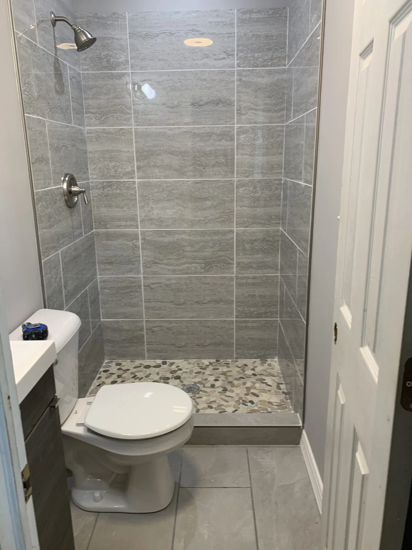 AFTER: tiled walk-in shower with pebble floor